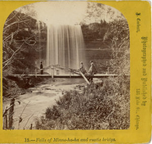 Mollie Carbutt standing between Edward L. Wilson, left, and Mrs. Wilson. Note that the bridge is not in good repair.